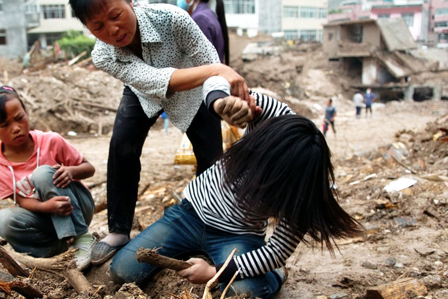 8月13日，悲伤的刘春花正疯狂地刨挖泥土，她的姑姑在一旁劝阻。