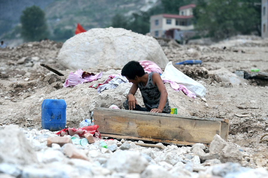 8月10日，张武成的哥哥张宏宏将张涛涛的遗体装入棺材后痛苦地扭过头去。灾害发生时，舟曲县城关乡月圆村村民张武成和妻子鲁朝菊没有回家，而他们的三个不过10岁的孩子却正在同一个屋子里睡觉，瞬间被埋在了废墟下。10日，最小的孩子张涛涛的遗体被救援人员挖出来。他们为孩子做了一个简易的小棺材。