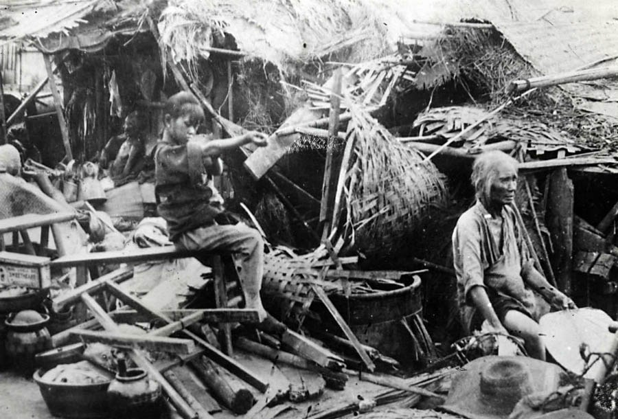 1930年，湖南，在中国内战期间人民家园被毁。幸存的人们在废墟中寻找东西。