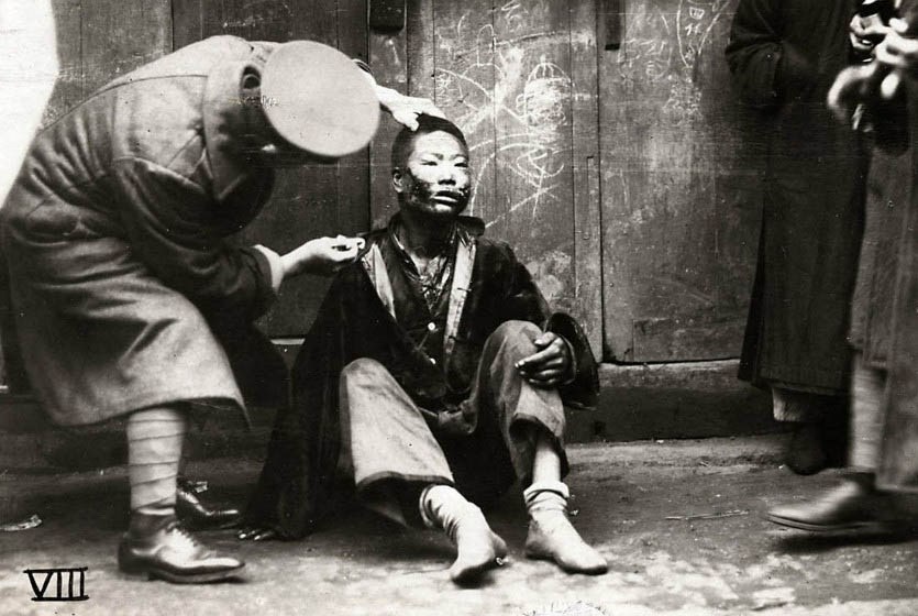 1927年，一位欧洲的医生帮助一个口腔遭步枪射击受伤的广东士兵。