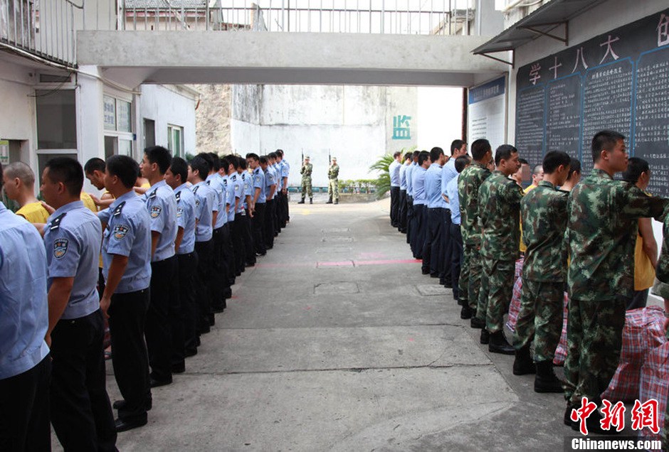 2013年7月9日，浙江省舟山市定海区看守所搬迁。300余名在押人员安全转移至距离城区10公里外的新所，330名武警、公安干警全副武装押解。图为公安干警检查在押人员的行李。琳红 摄 图片来源：CFP视觉中国
