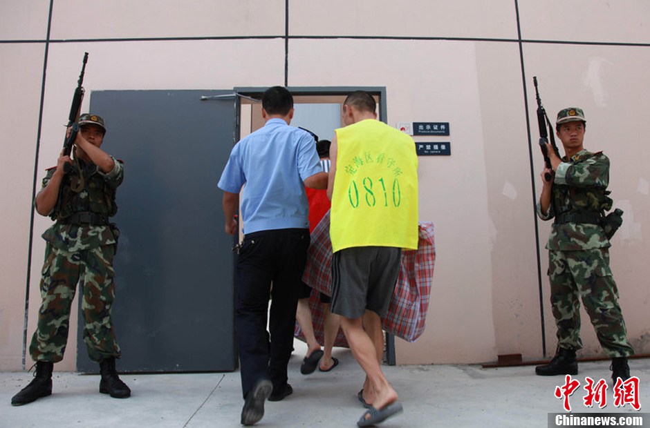 2013年7月9日，浙江省舟山市定海区看守所搬迁。300余名在押人员安全转移至距离城区10公里外的新所，330名武警、公安干警全副武装押解。图为公安干警检查在押人员的行李。琳红 摄 图片来源：CFP视觉中国