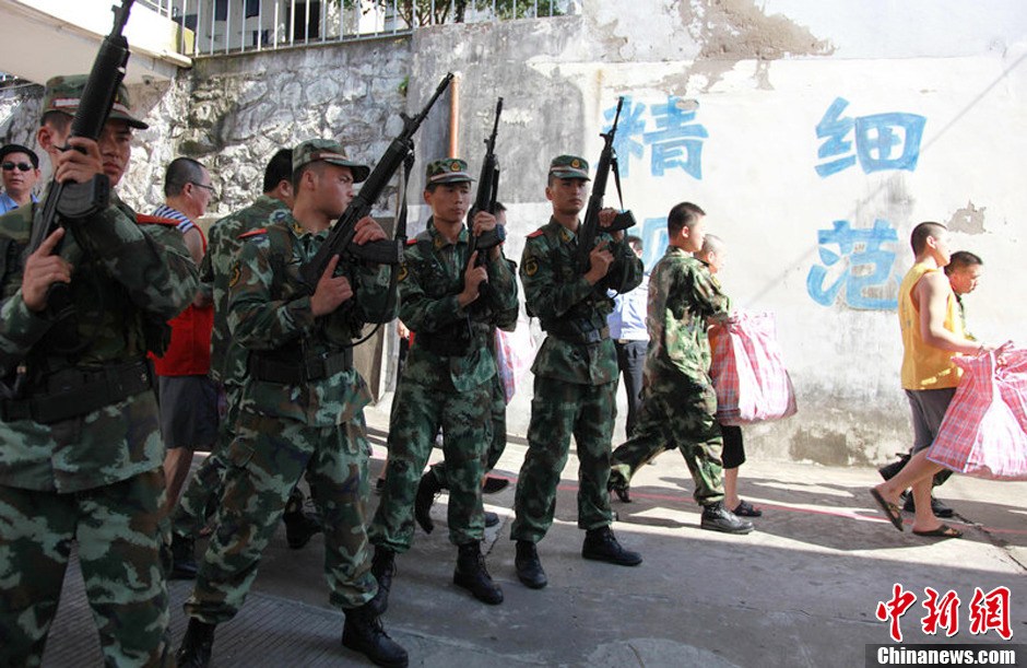 2013年7月9日，浙江省舟山市定海区看守所搬迁。300余名在押人员安全转移至距离城区10公里外的新所，330名武警、公安干警全副武装押解。图为公安干警检查在押人员的行李。琳红 摄 图片来源：CFP视觉中国