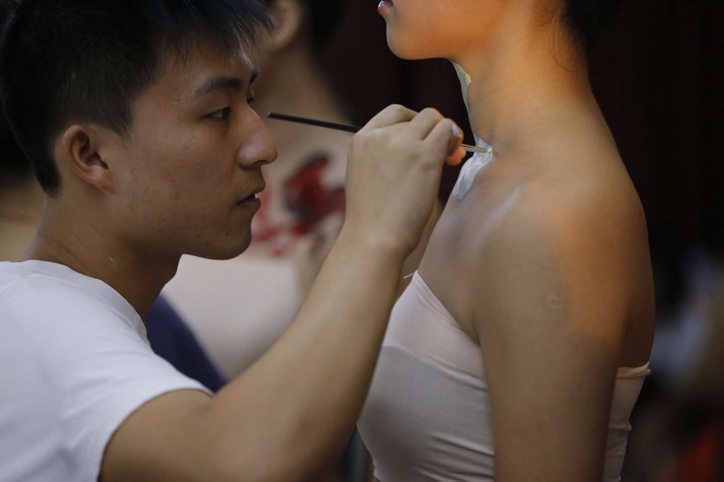 9月20日，2013国际旅游小姐菁英赛在湖北咸宁举行赛事活动，选自中国各地的40位佳丽来到咸宁市人民广场进行人体彩绘表演，吸引众多摄影爱好者及市民观赏。图为彩绘师作画。