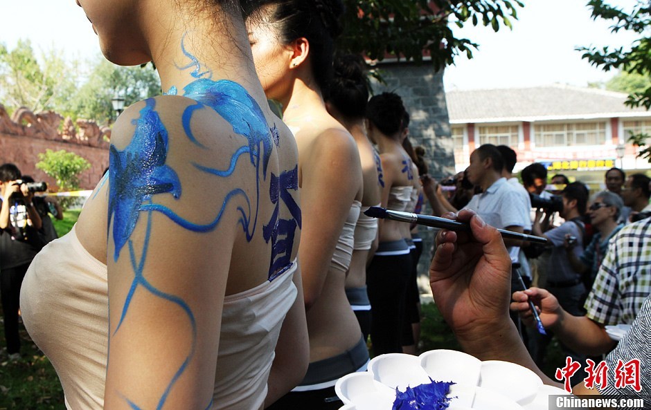 9月20日，2013国际旅游小姐菁英赛在湖北咸宁举行赛事活动，选自中国各地的40位佳丽来到咸宁市人民广场进行人体彩绘表演，吸引众多摄影爱好者及市民观赏。图为国际旅游小姐菁英赛参赛佳丽人体彩绘。中新社发 钱兴强 摄