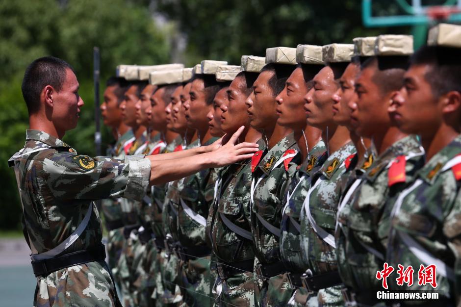 　　图为2014年7月22日上午11时许，武警四川省遂宁市支队训练场上，40余名国旗护卫中队官兵在烈日下刻苦训练，磨练超常意志迎接“八一”建军节。 中新社发 钟 敏 摄