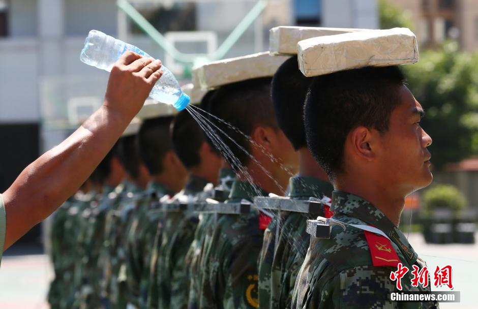 　　图为2014年7月22日上午11时许，武警四川省遂宁市支队训练场上，40余名国旗护卫中队官兵在烈日下刻苦训练，磨练超常意志迎接“八一”建军节。 中新社发 钟 敏 摄 图片来源：CNSPHOTO