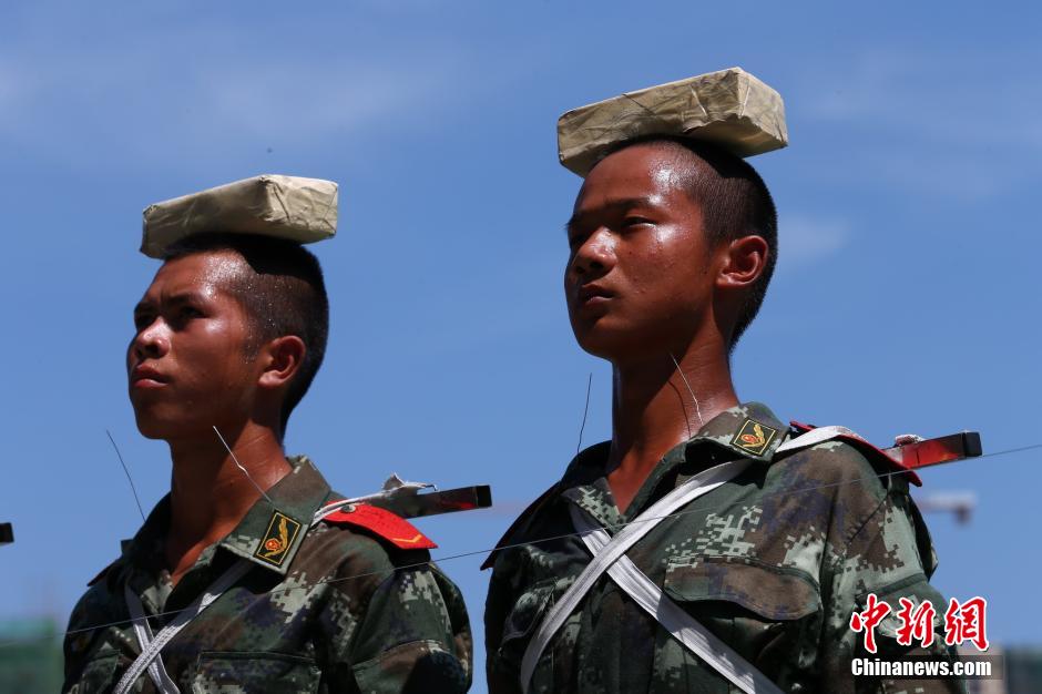 　　图为2014年7月22日上午11时许，武警四川省遂宁市支队训练场上，40余名国旗护卫中队官兵在烈日下刻苦训练，磨练超常意志迎接“八一”建军节。 中新社发 钟 敏 摄 图片来源：CNSPHOTO