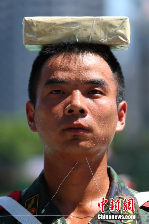 　　图为2014年7月22日上午11时许，武警四川省遂宁市支队训练场上，40余名国旗护卫中队官兵在烈日下刻苦训练，磨练超常意志迎接“八一”建军节。 中新社发 钟 敏 摄 图片来源：CNSPHOTO