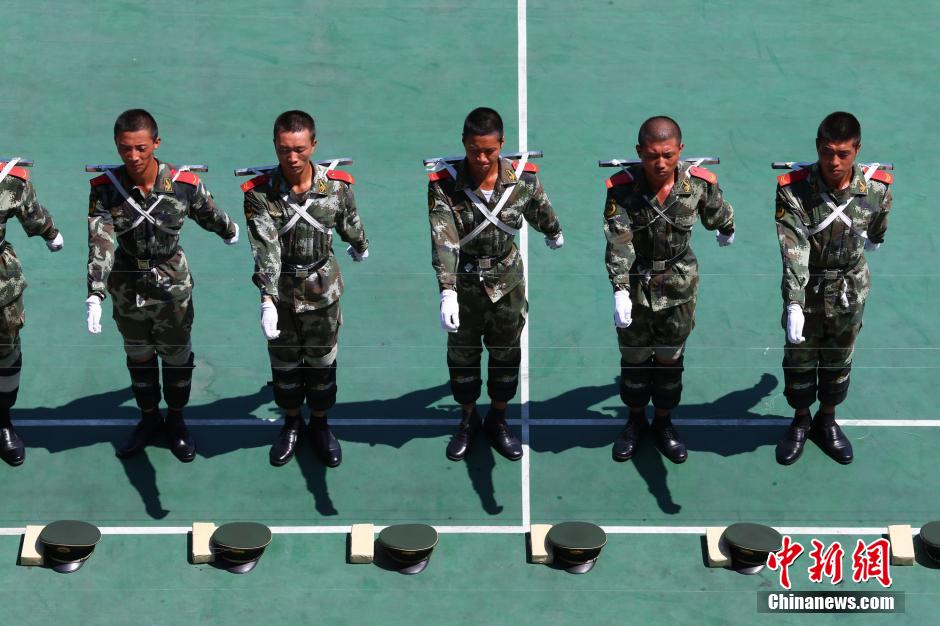 　　图为2014年7月22日上午11时许，武警四川省遂宁市支队训练场上，40余名国旗护卫中队官兵在烈日下刻苦训练，磨练超常意志迎接“八一”建军节。 中新社发 钟 敏 摄 图片来源：CNSPHOTO