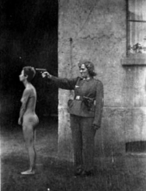 图为纳粹女军官枪杀犹太妇女。