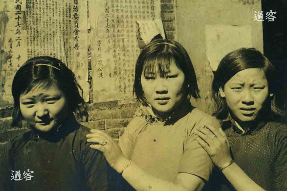 从军记者拍摄的南京城内的中国姑娘，这是沦陷后不久拍摄的照片。从三位女子的脸上，能看出来他们虽然勉强做出微笑的样子，实际上依然透露着恐惧和惊魂未定的神情。照片中，女子背后的墙上写着民国二十七年二月，即1938年2月。众所周知，南京大屠杀持续了六周左右，直到1938年2月才逐渐恢复秩序，而且这张照片里的女子都穿着短袖旗袍，所以照片应该是拍摄于南京大屠杀结束后。不过笔者推测，此照片应该是拍摄于1938年3月28日南京成立伪“中华民国维新政府”之前。（来源：网易新媒体）