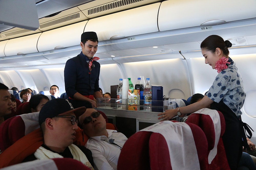 阮经天变身空姐在飞机上提供服务。