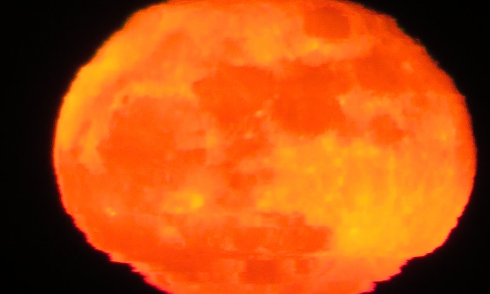 当月亮升起时，由于地球大气层的折射，月亮出现了橙色的闪光，边缘则出现了涟漪一般的褶皱。摄于满月过后的第二天。（来源：网易科技）