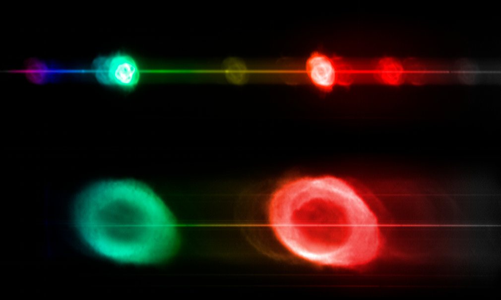 这张合成图利用无缝分光法从光谱特征上比较了两个知名的行星状星云——上部的NGC6543（猫眼星云）和下部的NGC6720（M57，即环状星云）。在光谱仪中，光线被分散成组成色。如果被分析的对象发射出所有波长的光线（如，每个星云中心的恒星），那么分析结果就会出现图中的水平线。然而，行星状星云很特别，因为它们只会发射某些特定波长的光，经仪器分析后会产生图中这种影像分离的结果。（来源：网易科技）