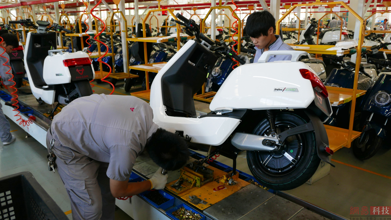 流水线不断向前，一辆辆小牛在添加各种组件后，逐渐成为一辆辆崭新的电动车。（来源：网易科技）