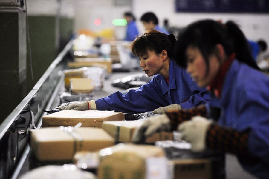 2012年1月15日，重庆渝北区龙头寺中国邮政快递分拣处，流水线上工人们在分拣快递物品。