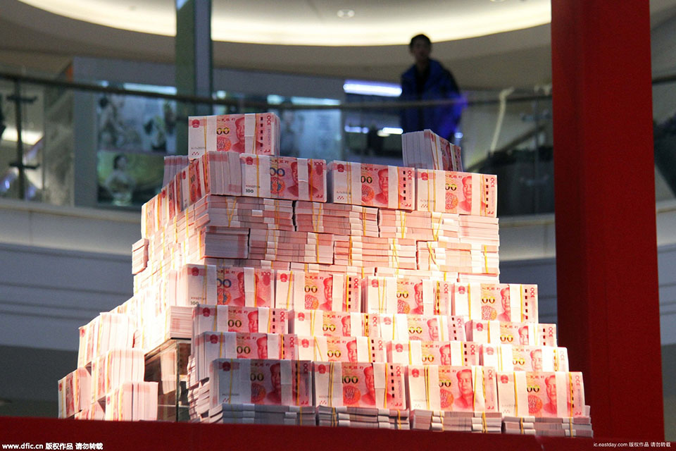 2015年11月26日，在河南省洛阳市一家商场内，写着“重金悬赏”字样的高台上，千万“土豪金”百元纸币堆起来在商场内展示，四周有射灯照在钱堆上，现场围起两道警戒线，有保安看管，吸引不少市民围观。（来源：海外网）