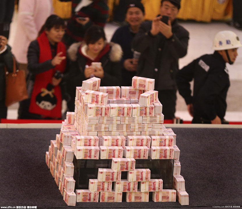 2015年11月26日，在河南省洛阳市一家商场内，写着“重金悬赏”字样的高台上，千万“土豪金”百元纸币堆起来在商场内展示，四周有射灯照在钱堆上，现场围起两道警戒线，有保安看管，吸引不少市民围观。（来源：海外网）