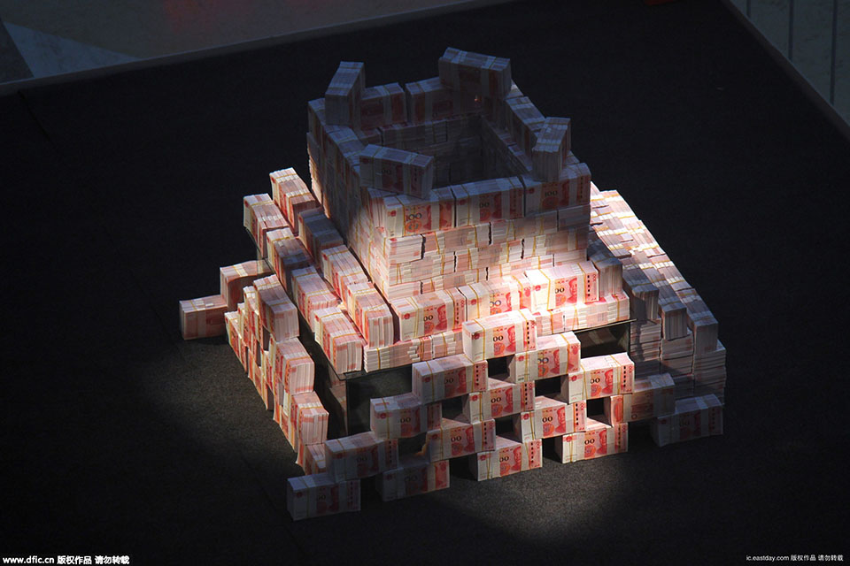 2015年11月26日，在河南省洛阳市一家商场内，写着“重金悬赏”字样的高台上，千万“土豪金”百元纸币堆起来在商场内展示，四周有射灯照在钱堆上，现场围起两道警戒线，有保安看管，吸引不少市民围观。（来源：海外网）
