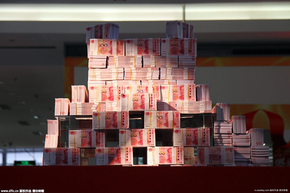 2015年11月26日，在河南省洛阳市一家商场内，写着“重金悬赏”字样的高台上，千万“土豪金”百元纸币堆起来在商场内展示，四周有射灯照在钱堆上，现场围起两道警戒线，有保安看管，吸引不少市民围观。（来源：海外网）