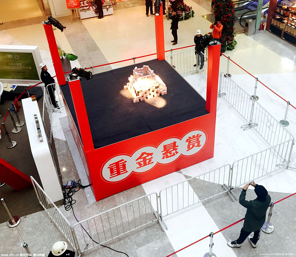 2015年11月26日，在河南省洛阳市一家商场内，写着“重金悬赏”字样的高台上，千万“土豪金”百元纸币堆起来在商场内展示，四周有射灯照在钱堆上，现场围起两道警戒线，有保安看管，吸引不少市民围观。（来源：海外网）