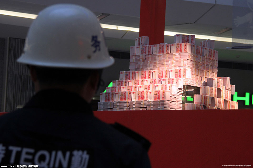 2015年11月26日，在河南省洛阳市一家商场内，写着“重金悬赏”字样的高台上，千万“土豪金”百元纸币堆起来在商场内展示，四周有射灯照在钱堆上，现场围起两道警戒线，有保安看管，吸引不少市民围观。（来源：海外网）