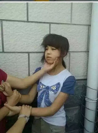 近日，网络曝出疑似多名女初中生群殴女同学的照片，引发关注。目前，尚无法确定事发具体地点，西安市莲湖区、太原市晋源区警方正了解相关情况。7月15日，记者看到，照片中，一穿蓝白短袖的女孩被五六名女孩勒脖、踩头，被迫下跪，还被扒掉上衣。