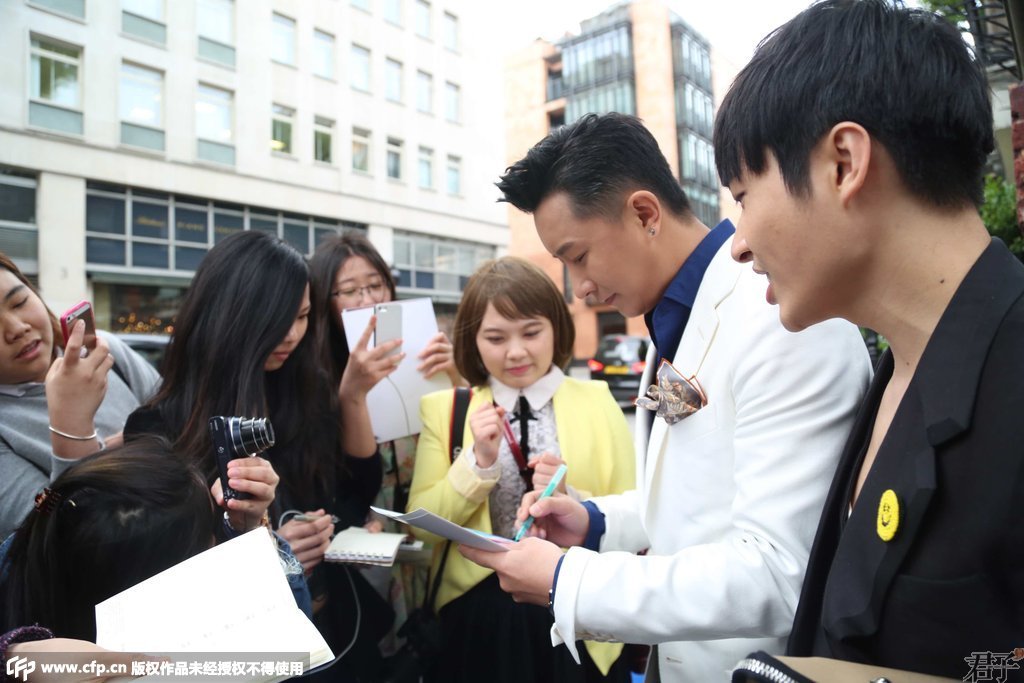 最近人气回暖的韩庚在为场外粉丝签名。