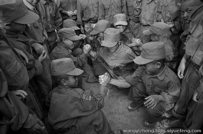 近日，有网友曝出了缅甸佤邦军“娃娃兵”们的训练生活照片。手持81杠，站军姿、练步伐。可以看出训练的内容与解放军的操练几乎一样。除此之外，孩子们学习的也是中国文化，书本黑板上的汉字醒目。这些孩子有着不一样的童年，条件艰苦，令人心酸。